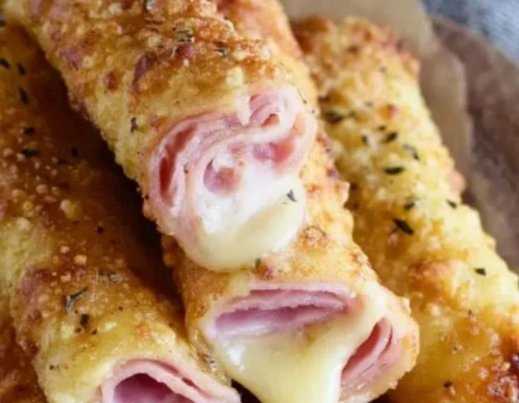Crispy baked ham cheese mozzarella sticks on a plate with dipping sauce.