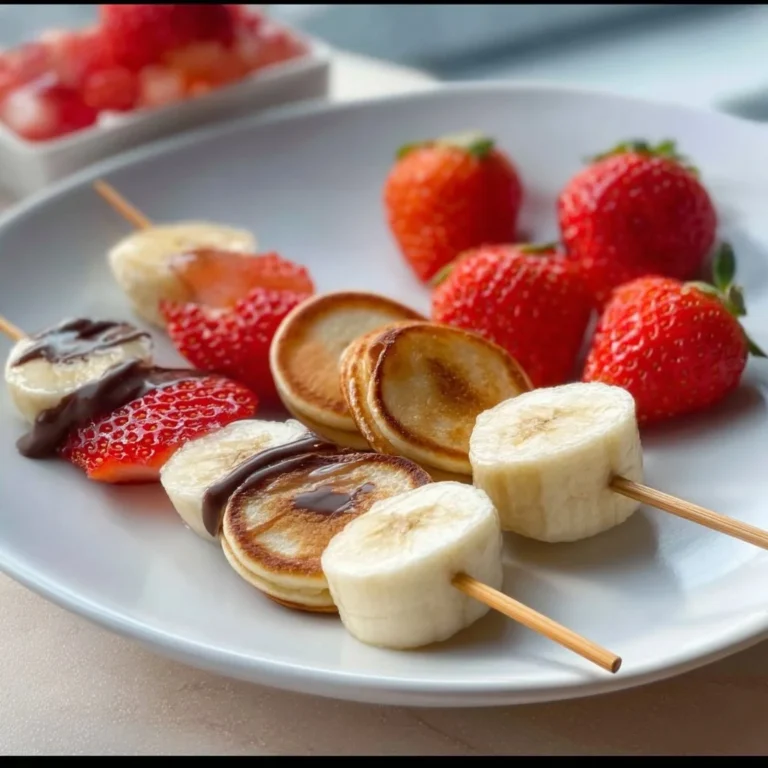 Mini pancake skewers with strawberries, banana slices, and chocolate drizzle